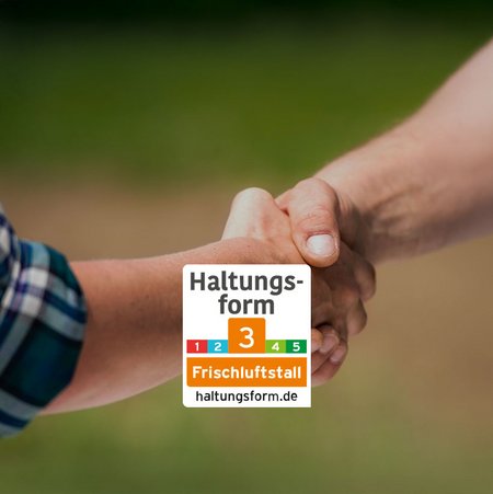 Zwei Menschen reichen sich die Hand, man sieht aber nur die Arme. In der unteren Bildmitte ist das Siegel für die Tierhaltungsform 3 zu sehen. 